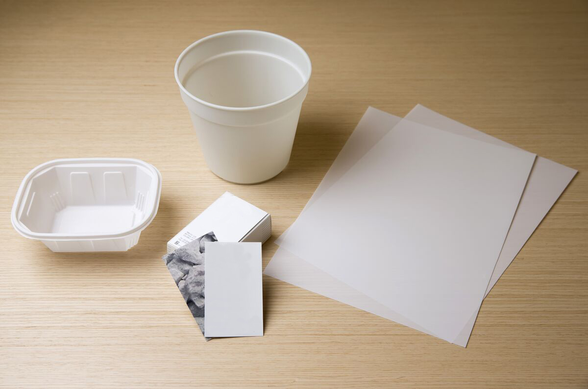A photo showing various products made from stone paper, including a container and a business card.